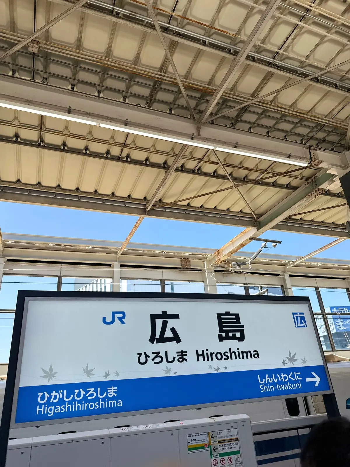 広島駅を示す看板で、青い背景に「広島」と日本語と英語で表記され、右側に「新岩国」への方向を示す矢印がある