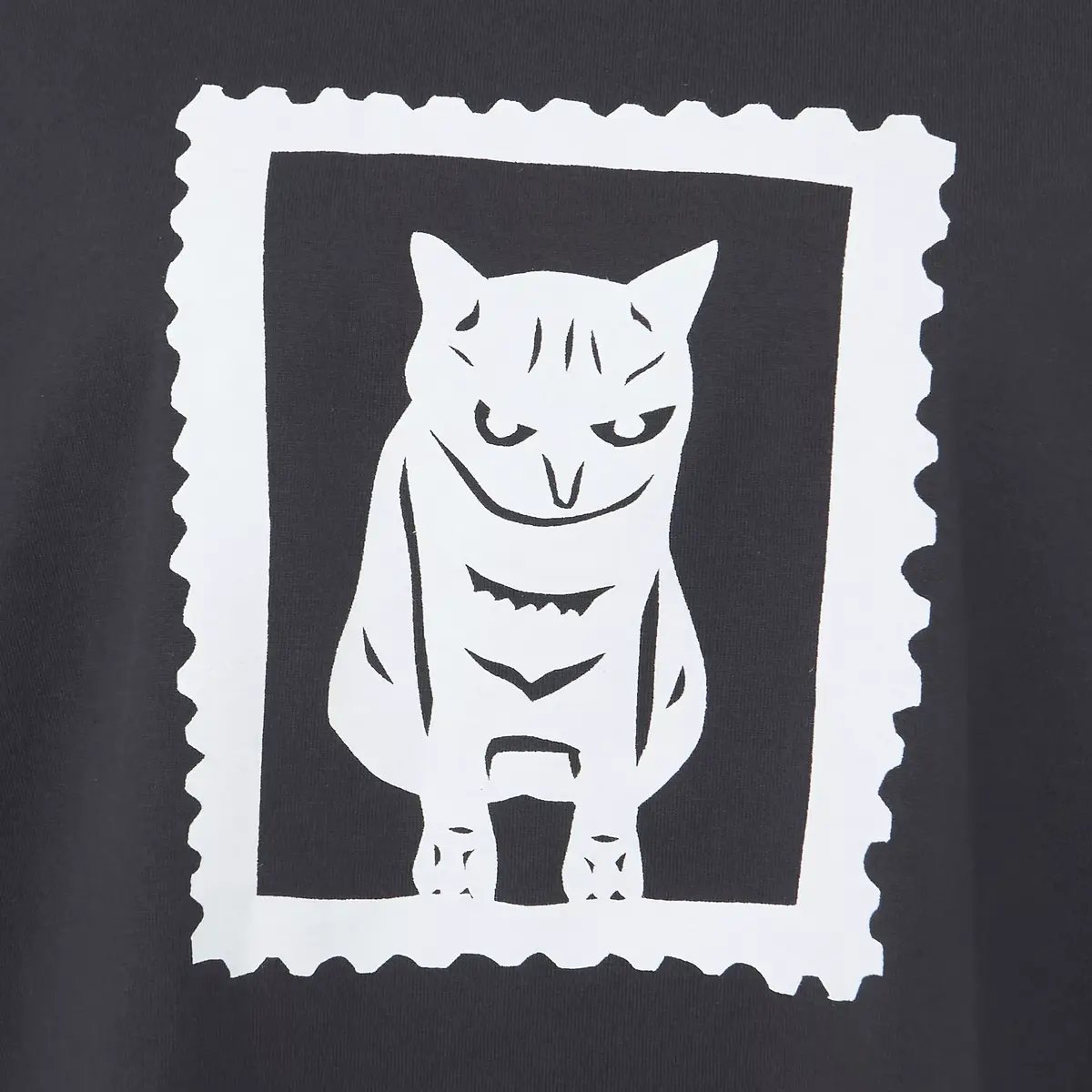 黒いTシャツに、白い猫のイラストがプリントされている。イラストは、郵便スタンプのような白い枠で囲まれている。
