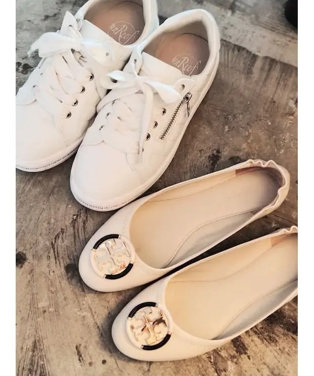 白いスニーカー2足と、 Tory Burch（トリーバーチ）のロゴが付いた白いフラットシューズが置かれている。スニーカーは白い紐で飾られ、フラットシューズはフリル縁取りになっている。