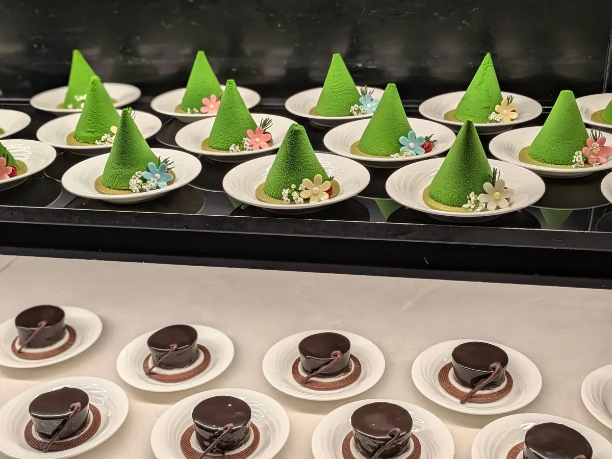 緑のモンブランとチョコレートケーキが白いプレートに並んでいる
