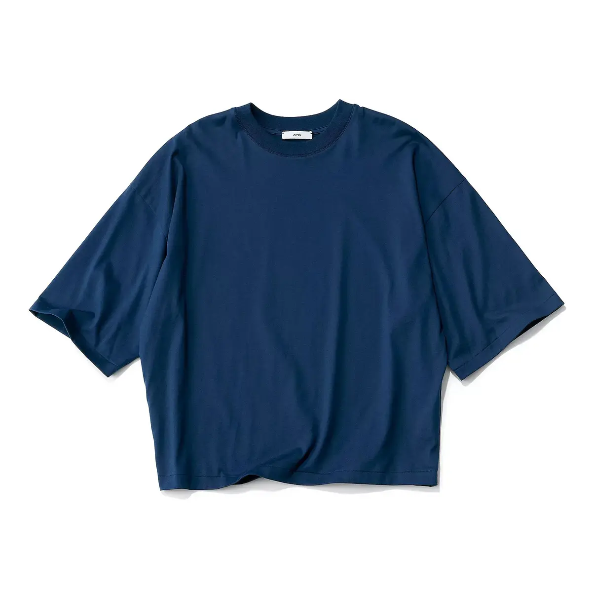 濃紺色のオーバーサイズTシャツ。丸首で、ゆったりとした袖が特徴。中央に小さくロゴマークが入っている。