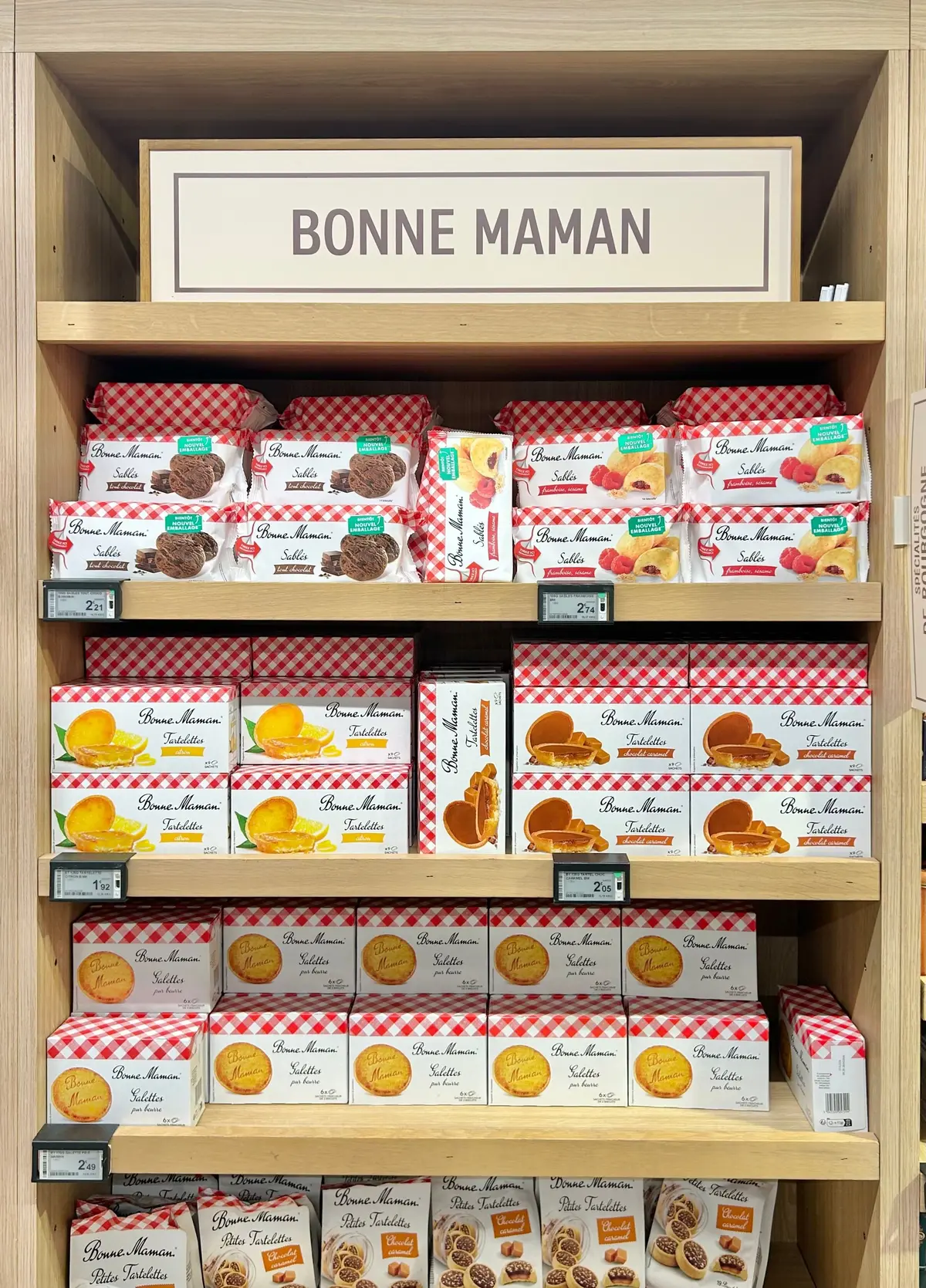 ボンヌママンのクッキーやタルトが赤と白のチェック柄パッケージで並んだ木製棚
