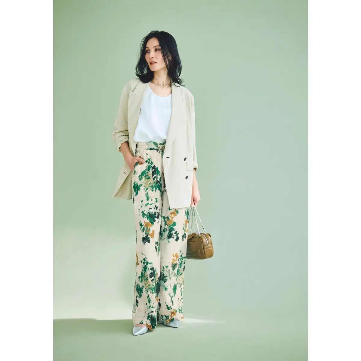 アイボリーのジャケットに白トップス、フラワープリントパンツを合わせたコーディネート　モデル・田沢美亜