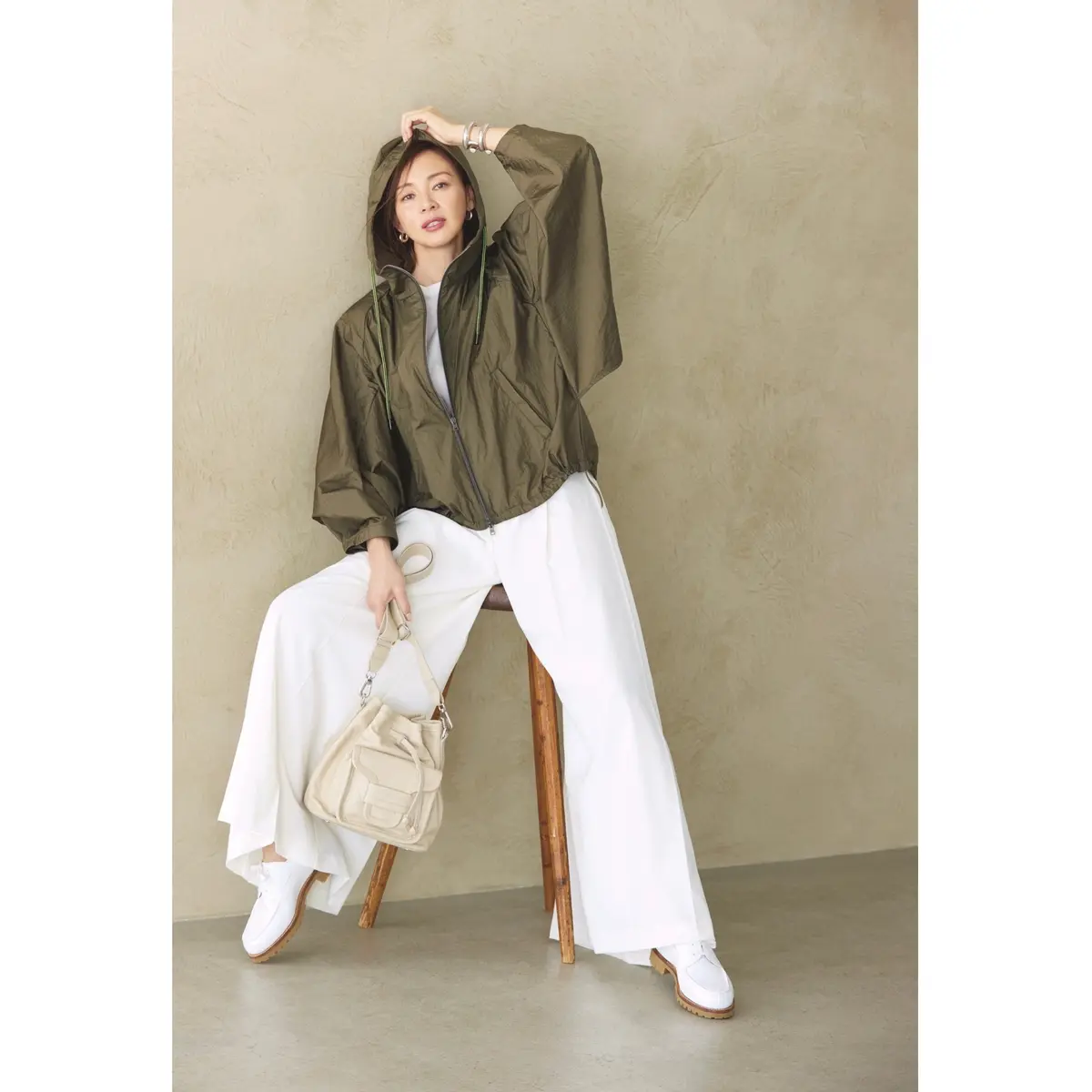 カーキのフードつきナイロンブルゾンと白ワイドパンツを合わせたコーディネート　モデル・SHIHO