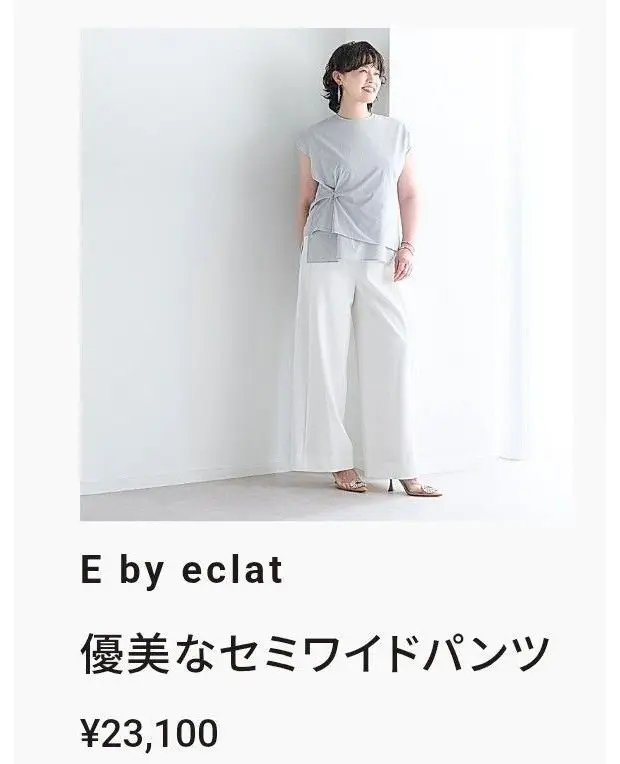 E by éclatの「優美なセーラードパンツ」の着用イメージ。グレーのトップスに白いワイドパンツを合わせた、シンプルなコーディネート。女性が正面を向いて立っている。