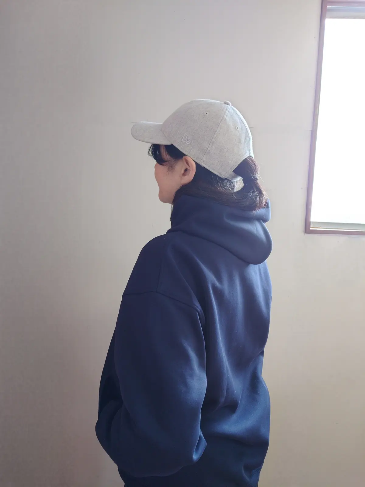 ユニクロメンズパーカーとニューエラキャップの後ろ姿