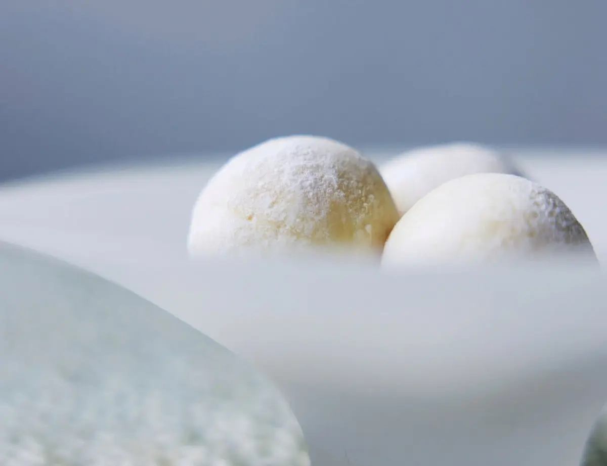 菓心おおすが「 沙羅」　和製トリュフ　夏スイーツ　粉をまぶした白い丸いお菓子が、緑と白の模様のある白いプレートに3つ並んでいる
