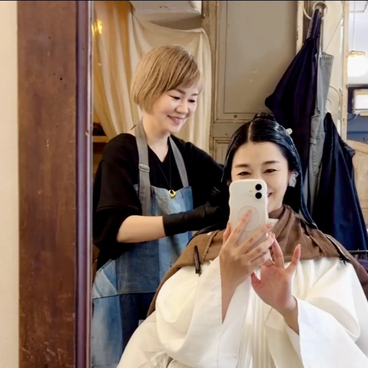 ・ヘアトリートメント施術中の美容師さんとお客様の画像・笑顔の2人の女性