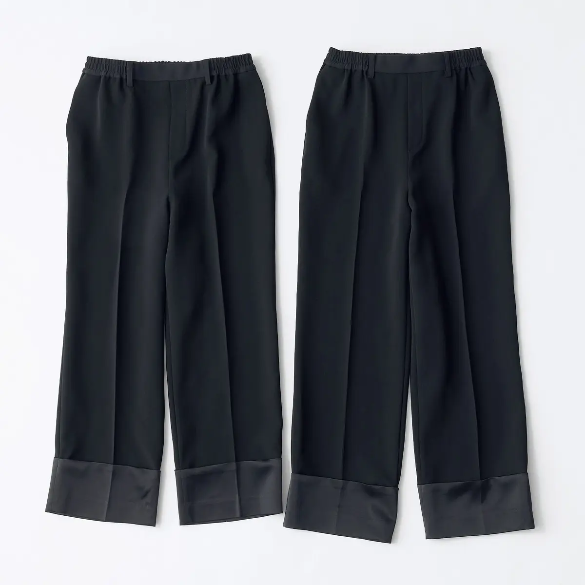 黒いワイドパンツ2着が白い背景に立てかけてある。裾が広がったデザインで、ウエストにはゴムが入っている。