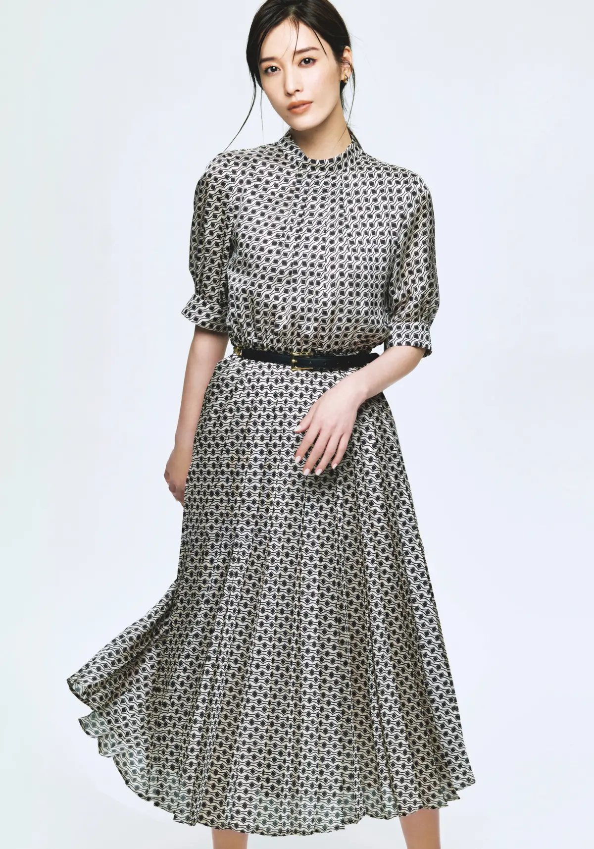 ジオメトリック柄のワンピースが華やか。春風と遊ぶように舞うプリーツが余韻を残す