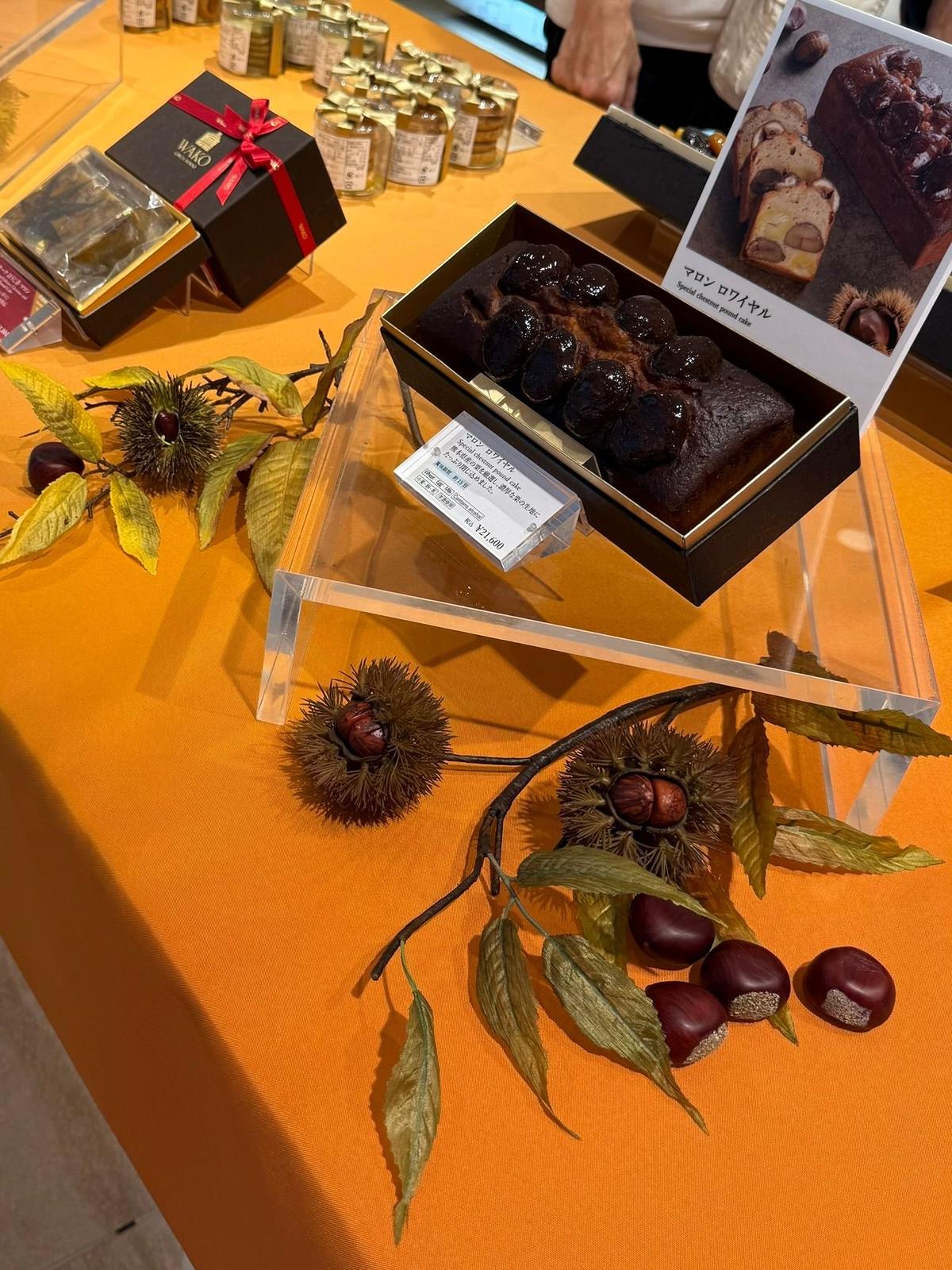 テーブルに並べられた和菓子のディスプレイ。WACOの箱に入った焼き菓子、栗の形をしたチョコレートケーキ、そして栗の実や枝を使った飾り付けが施されている。
