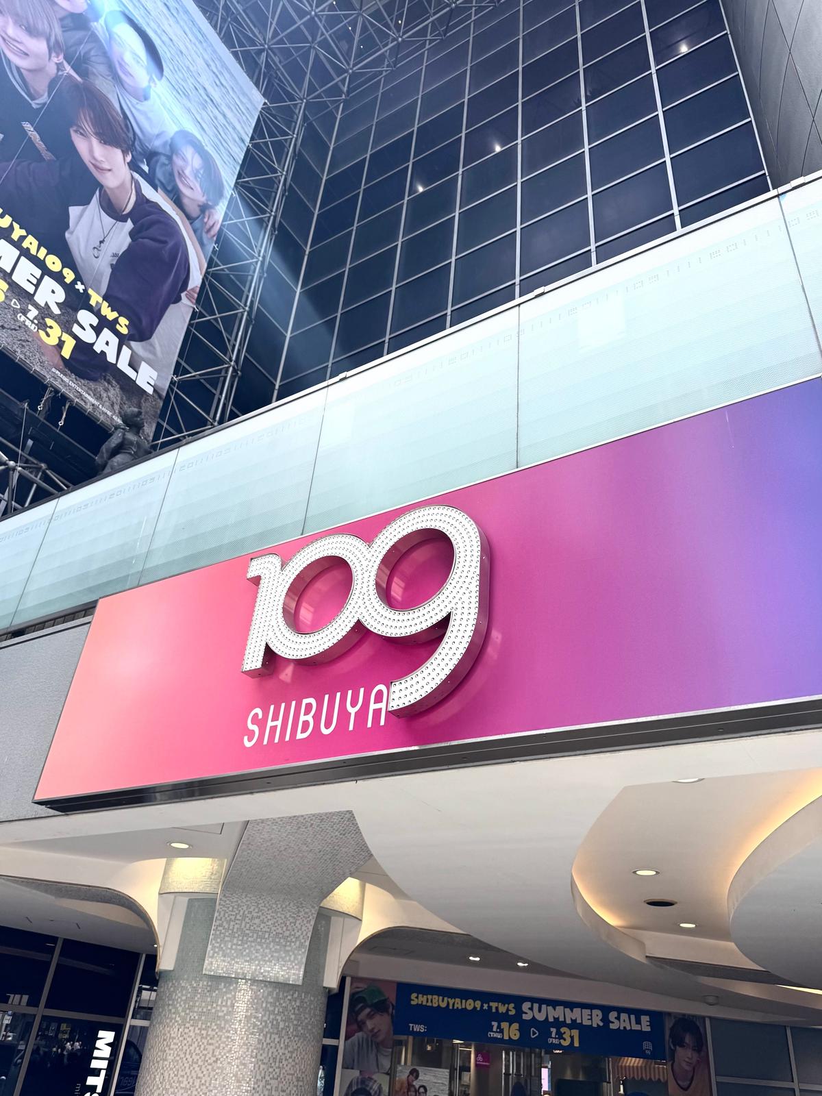 SHIBUYA109の看板。白地にピンクと赤のグラデーションの背景に、中央に大きな数字の「109」がデザインされている。看板の上には広告が表示されている。
