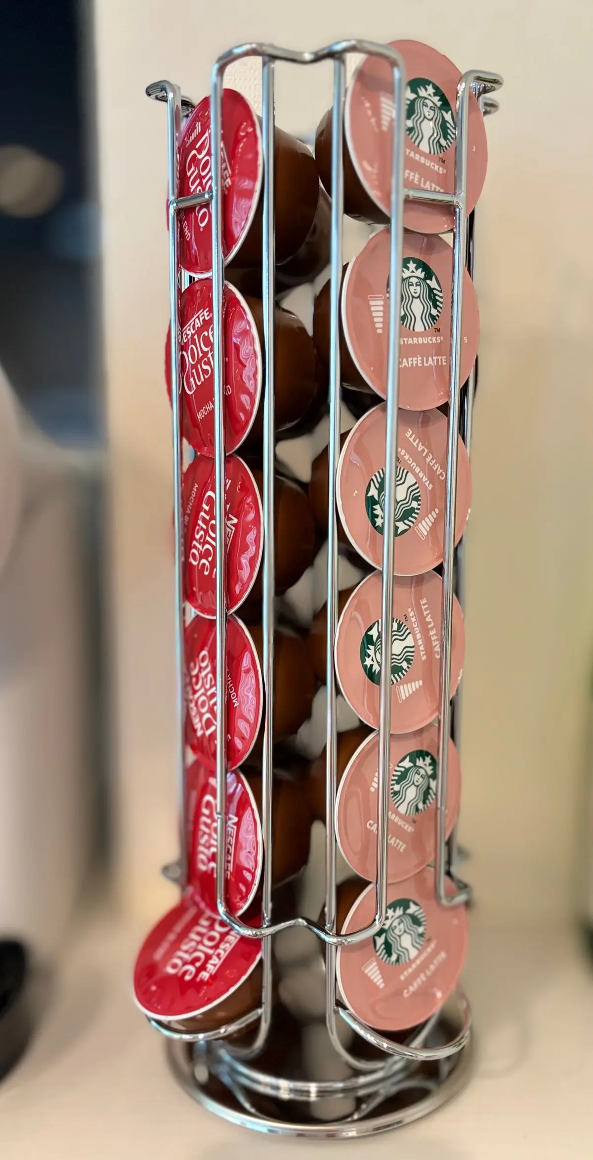 ネスプレッソのカーブ型ホルダーに、スターバックスのカプセルが並んでいる。ベージュと緑色のカプセルが、螺旋状に配置されている。