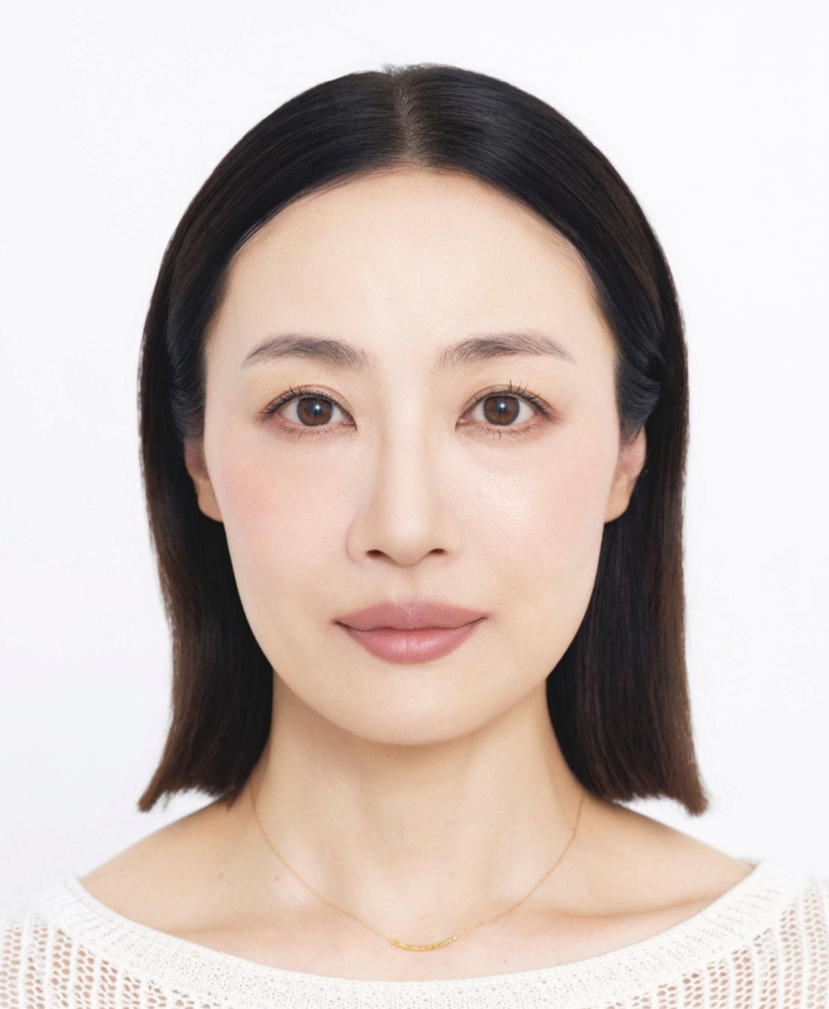 After黒髪で前髪のある女性が白い背景に映り、薄いピンクの口元と金のチェーンネックレスを身につけている