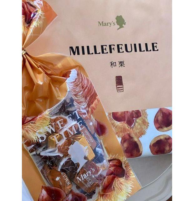 Mary's Millefeuilleの箱と、中に入ったお菓子の袋。箱はベージュ色で、和菓子とミルフィーユのイラストが描かれている。袋は茶色と白の模様で、Mary'sのロゴと「SWEETS TIME」の文字が印刷されている。