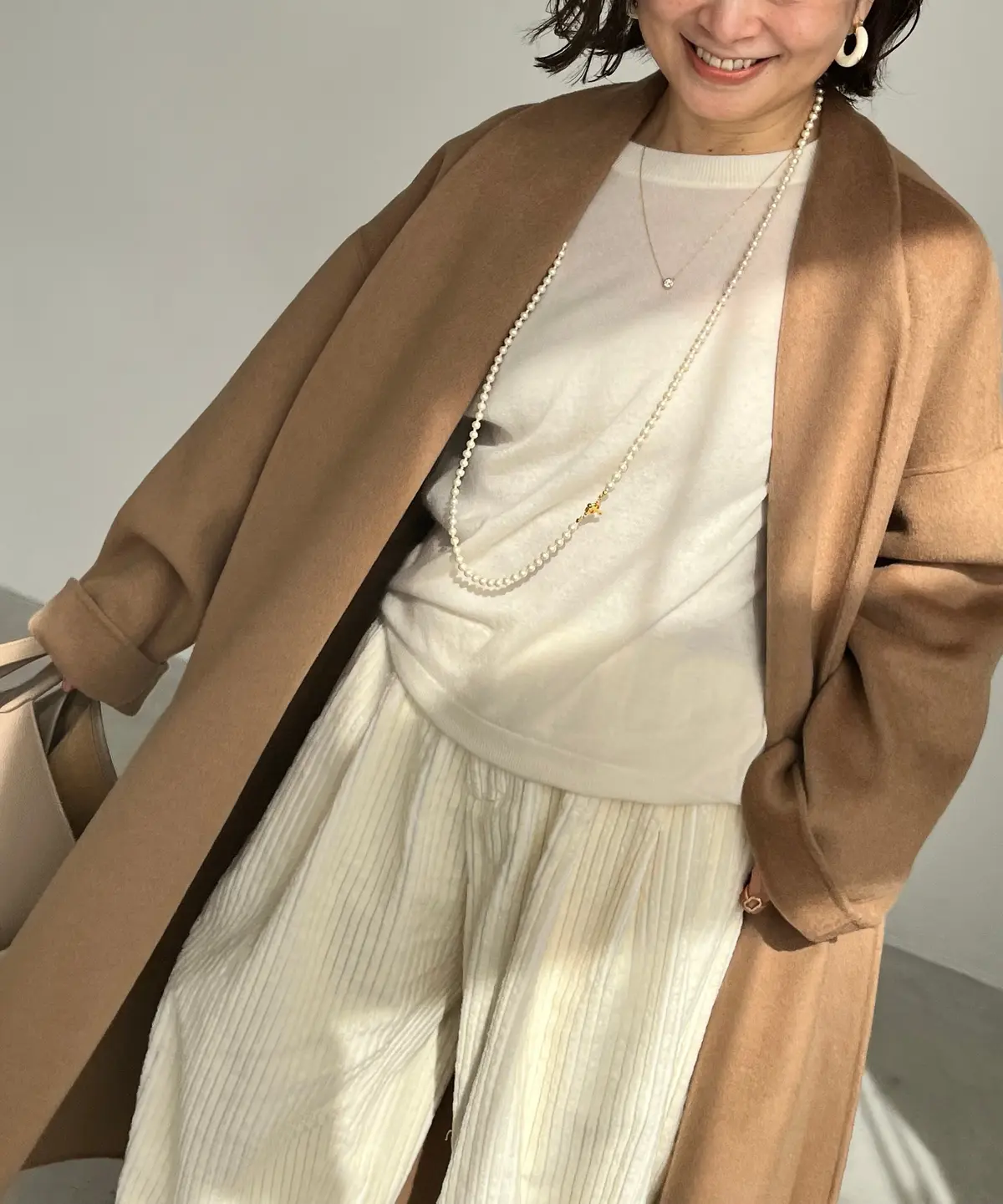 三尋木奈保さん、ベージュコートのインに着たニット　パンツ