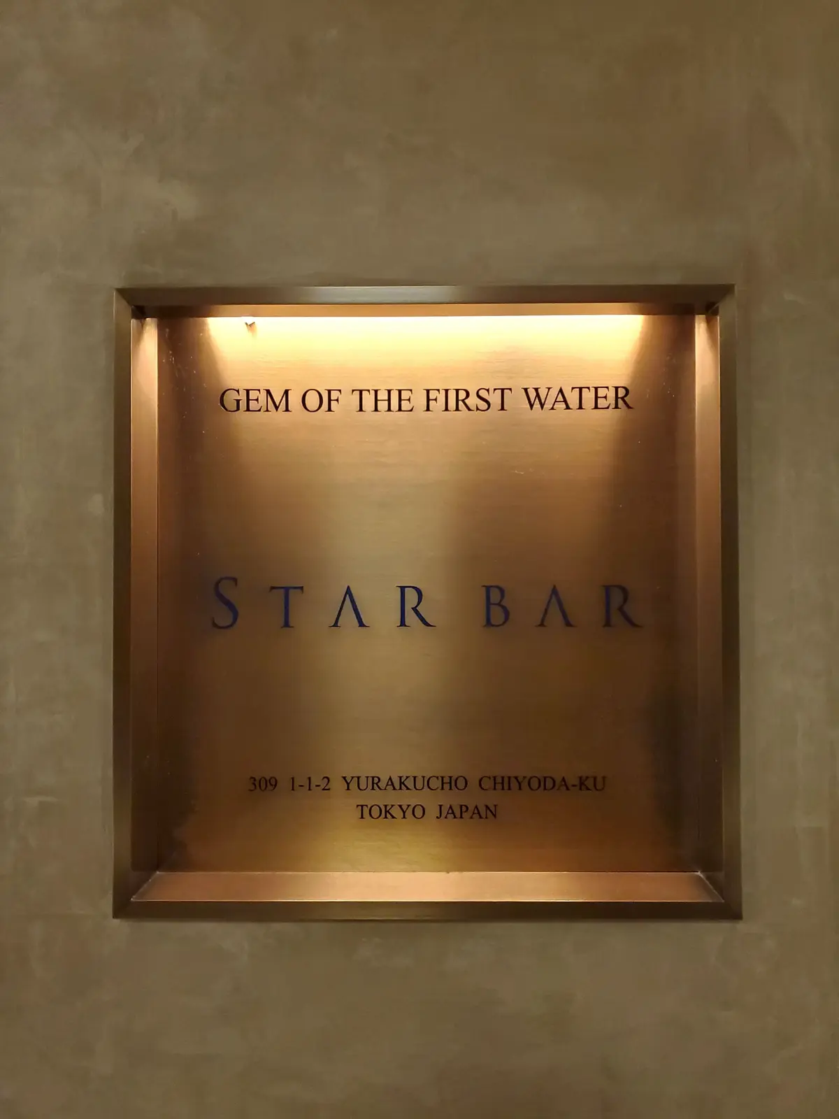 金色のフレームに「GEM OF THE FIRST WATER STAR BAR」と英語で書かれた看板、東京の住所表示付き