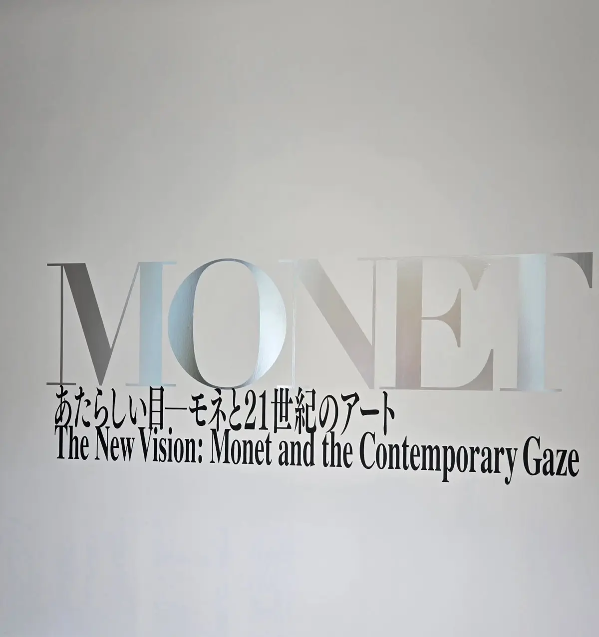 白壁に黒文字で「MONET」と大きく書かれた看板。