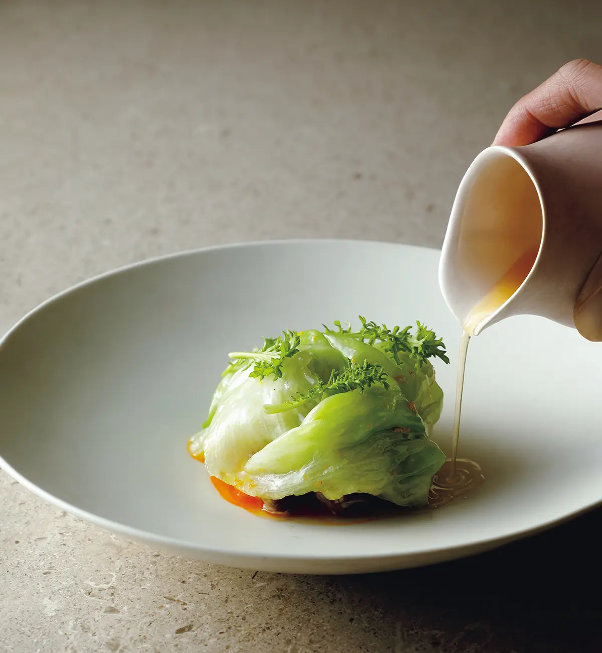 『VILLA COMMUNICO』の コースより。寒ブリに昆布だ しでゆでたレタスを重ね、柑 橘の不しらぬい知火や発酵麴ウォータ ーを使ったソースをかけて。 ブリしゃぶをイメージ