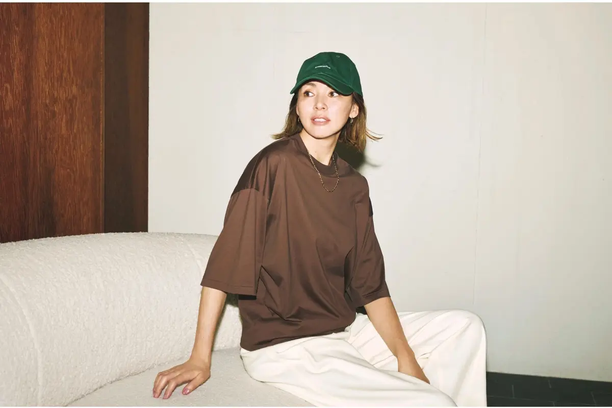 ブラウンのオーバーサイズTシャツに白ゆるパンツとグリーンキャップを合わせたコーディネート　モデル・SHIHO