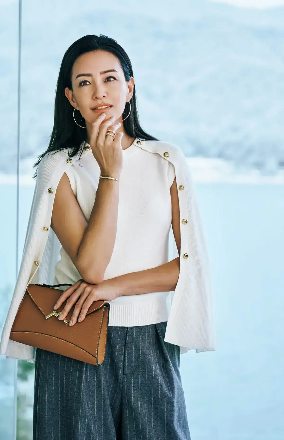 ノースリーブニットにケープを重ねた一枚は、動きに合わせて二の腕がのぞく仕掛け