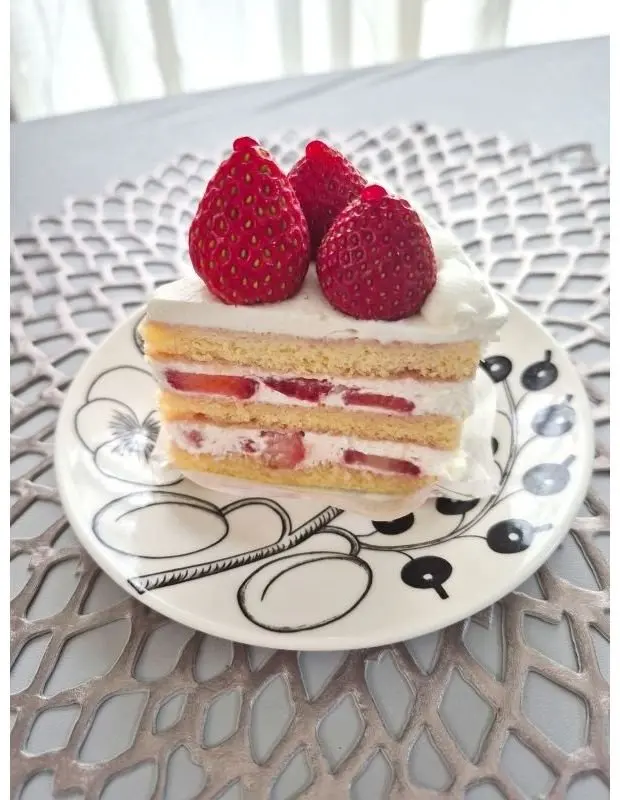 イチゴとクリームがのったサンドイッチケーキが白いプレートにのっている