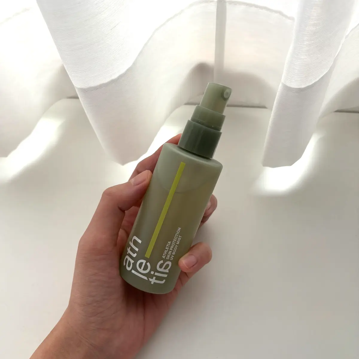 アスレティアの「スキンプロテクション UVボディミスト」を使用する際、手に持った様子