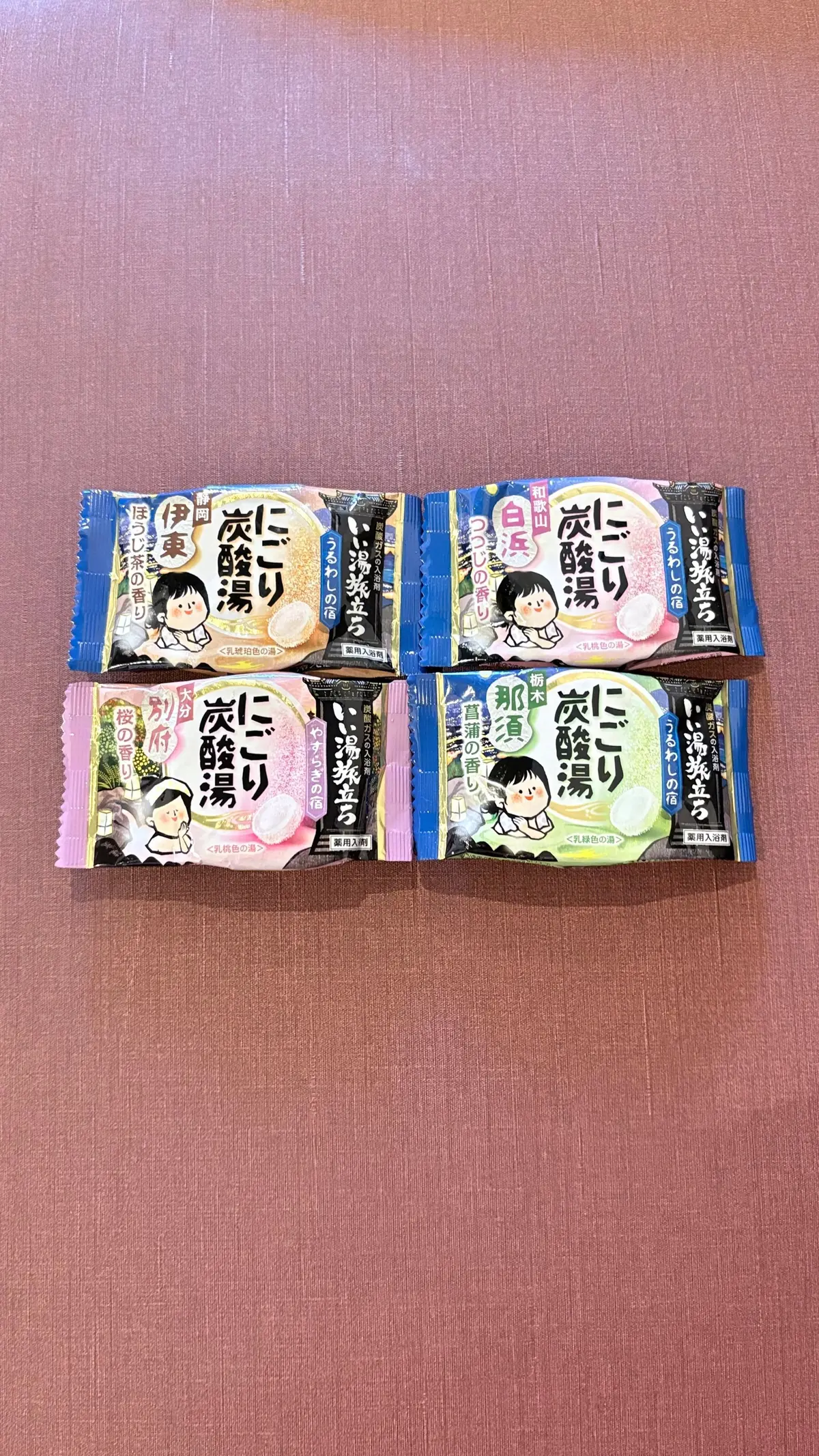 「ピリ辛」ブランドの様々なフレーバーの辛いラーメンカップ麺6個が、茶色い木製のテーブルの上に並んでいる。各カップ麺は異なるイラストとフレーバー名が記載されている。