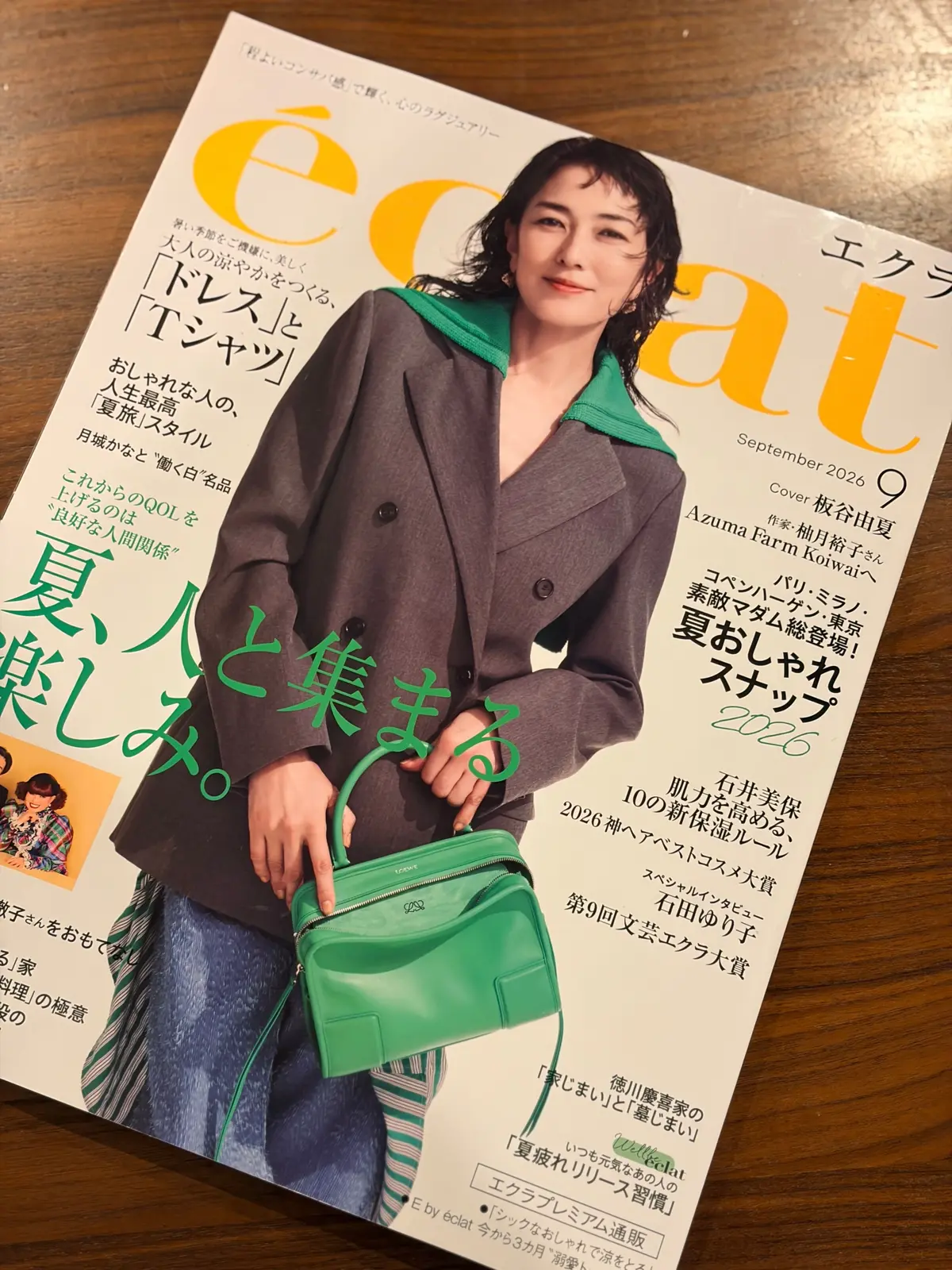 エクラ9月号の表紙。坂出早苗さんが、緑色のバッグを持って微笑んでいる。背景には、雑誌のタイトルや記事の見出しが日本語で記載されている。