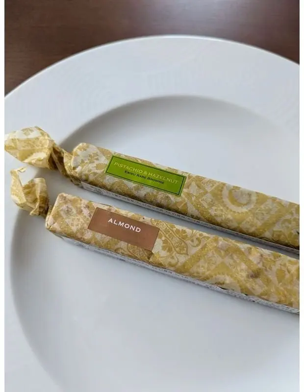 白い皿に、ピスタチオとヘーゼルナッツ入りチョコレートとアーモンド入りチョコレートの2本のチョコレートバーが置かれている。