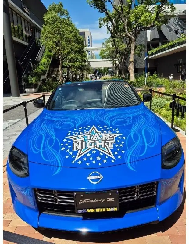 青い日産フェアレディZ。車体全体に青色の星や模様が描かれ、「YOKOHAMA STAR NIGHT」の文字がデザインされている。前面に「Fairlady Z」のロゴと「WIN WITH MOON」の文字が入ったライセンスプレートが装着されている。
