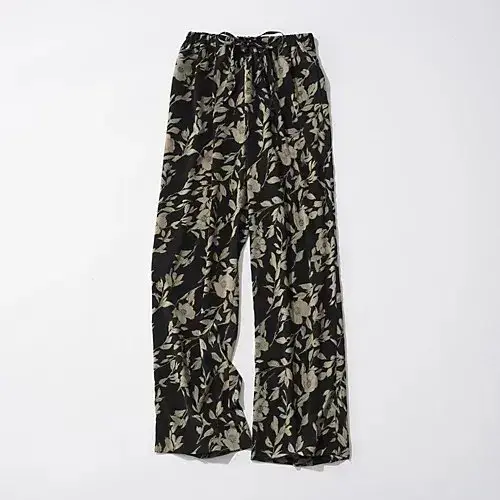 黒地にベージュの花柄が散りばめられた、ワイドレッグのパンツ。ウエストはゴムで絞れるデザイン。カジュアルな印象。
