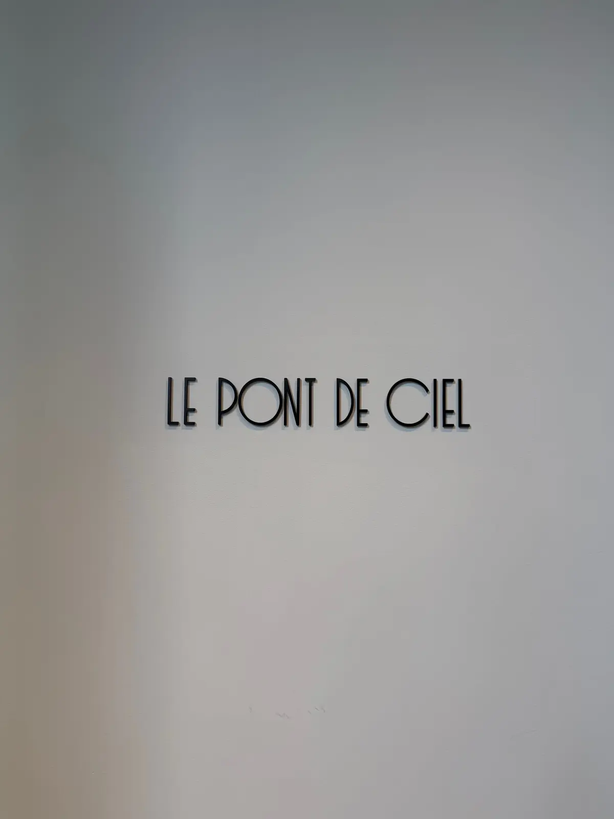 淡い灰色背景に中央に「LE PONT DE CIEL」という黒い文字が書かれている。