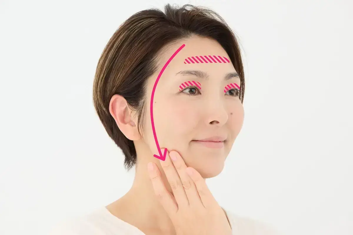 額の生え際からこめかみ、耳の前を通ってエラ付近まで、すーっと優しくなでるようにのばします