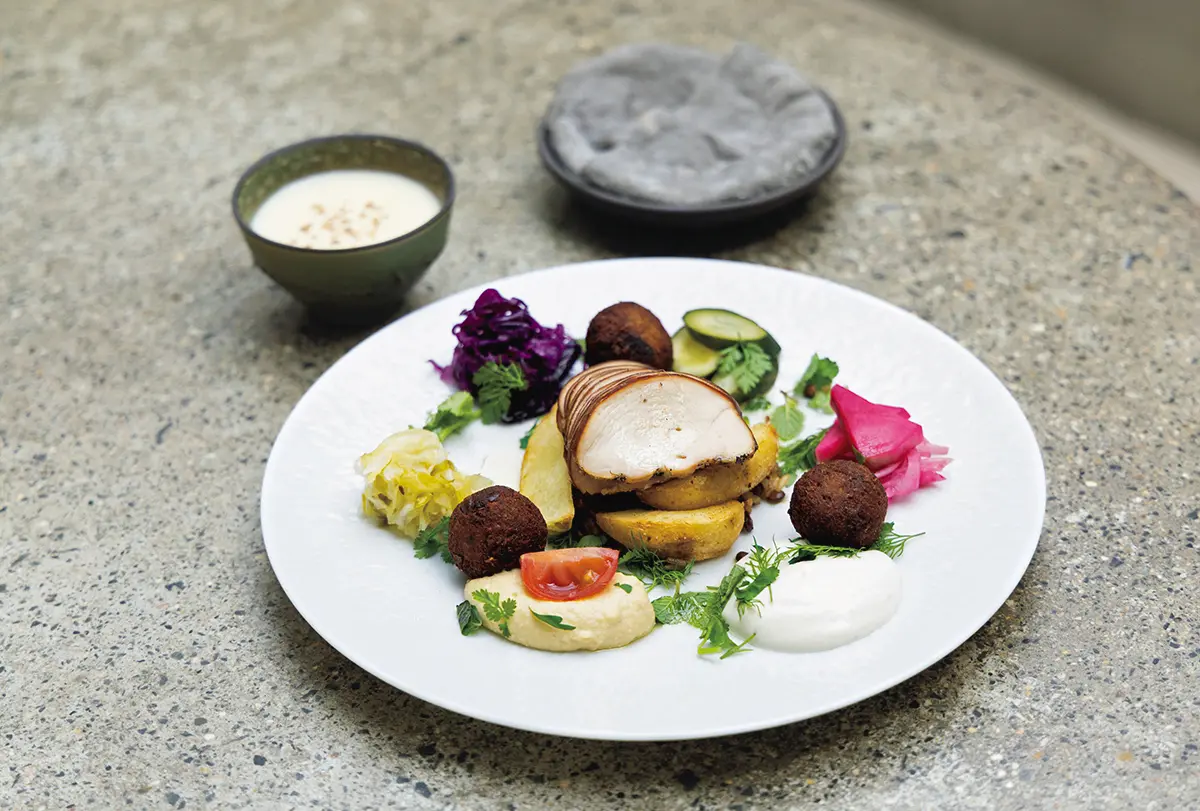 チキンとファラフェルにフムス、ザワークラウトなどの野菜を盛り合わせたプレートにピ タパンとスープがつく朝食¥1,900。大テーブルを囲む、気取りのないスタイルで楽しめる