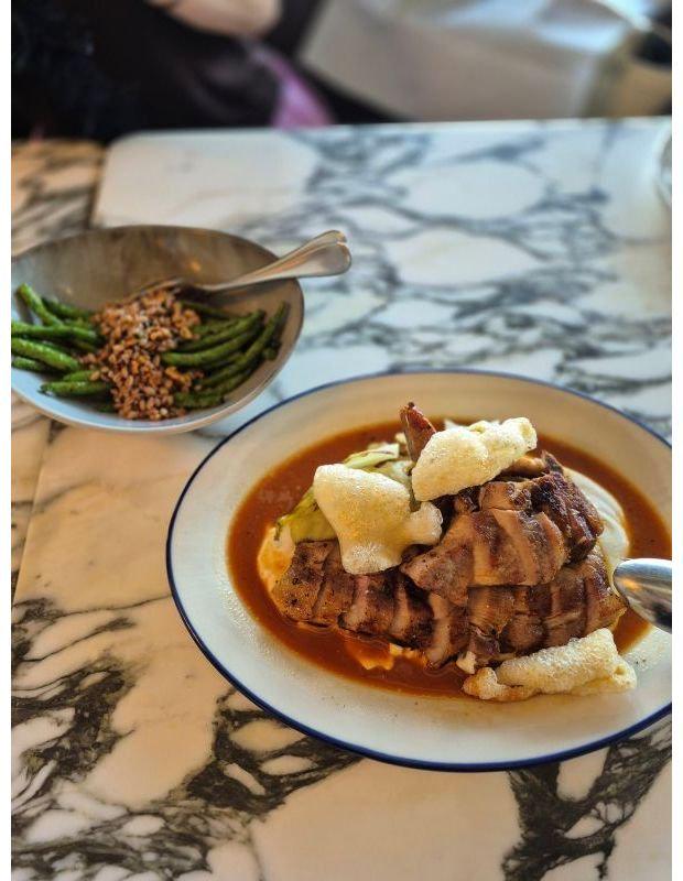 マーブル調のテーブルに、緑豆とグリーンピースの入ったボウルと、肉と揚げ野菜が乗った煮込み料理の皿が並ぶ