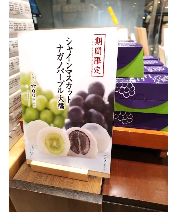 「桔梗屋」の期間限定商品「シナノスイートカット ナガノパープル 大福」の告知ポスター。白地に紫色の文字で商品名と「期間限定」の記載がある。大福の断面のイラストが中央に配置され、左にはライム、右にはナガノパープルの写真。価格は600円（税込）。