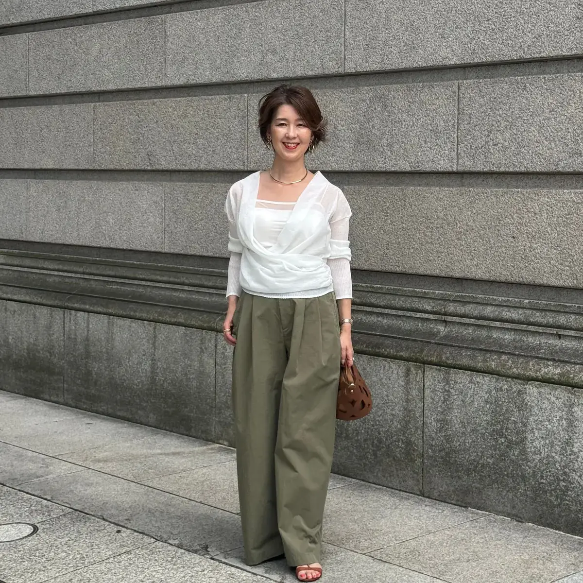 透け感のある白のトップスにカーキのワイドパンツを合わせた大人のカジュアルスタイル
