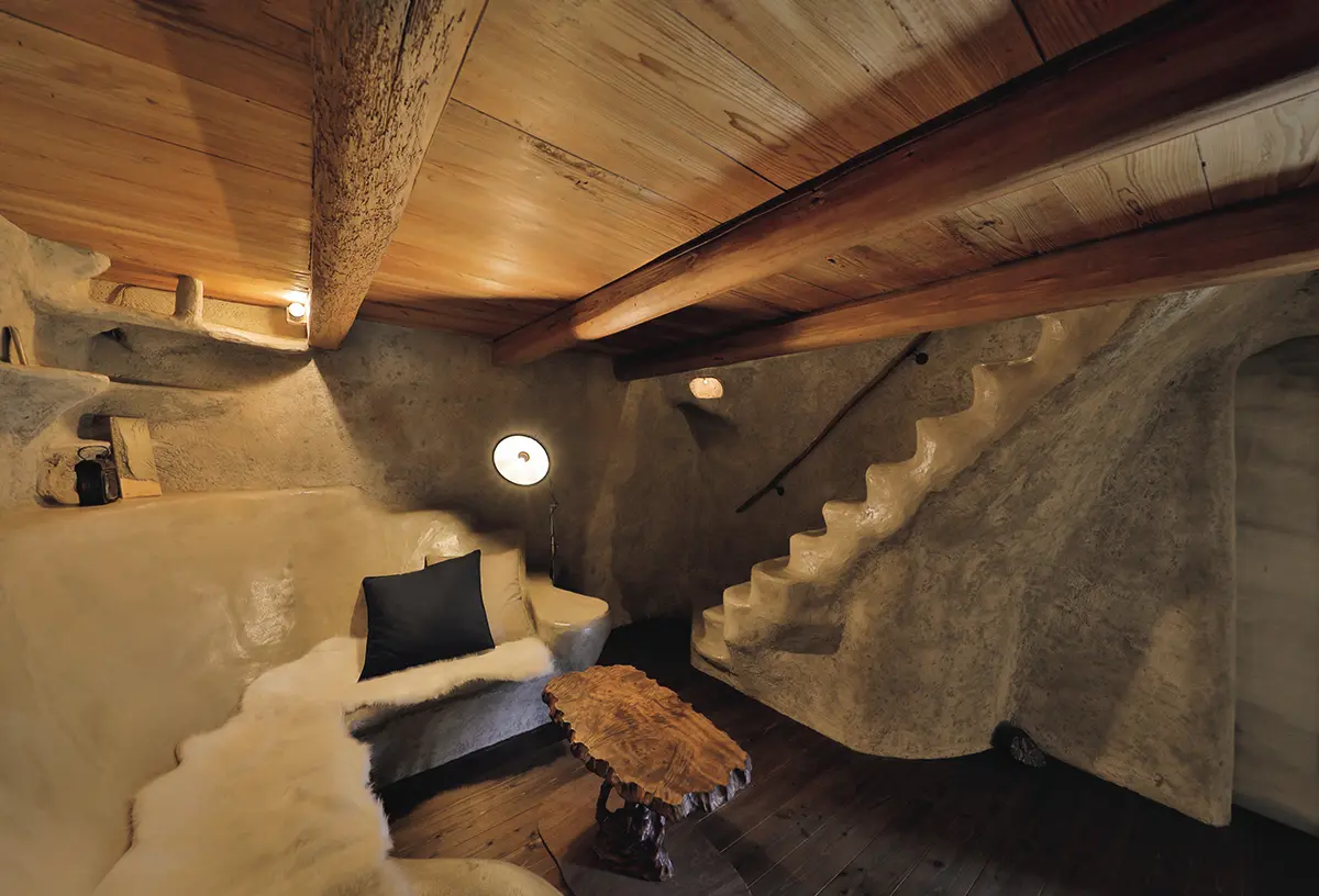 古墳の土を混ぜて仕上げた壁 に包まれた、地下の洞窟のよ うな客室。土の棟「つち」