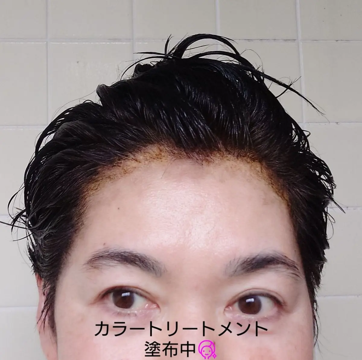 背景は白いタイル壁。髪が濡れて、まとめている女性テキスト「カラーリートリートメント 塗布中」が中央に表示されている。