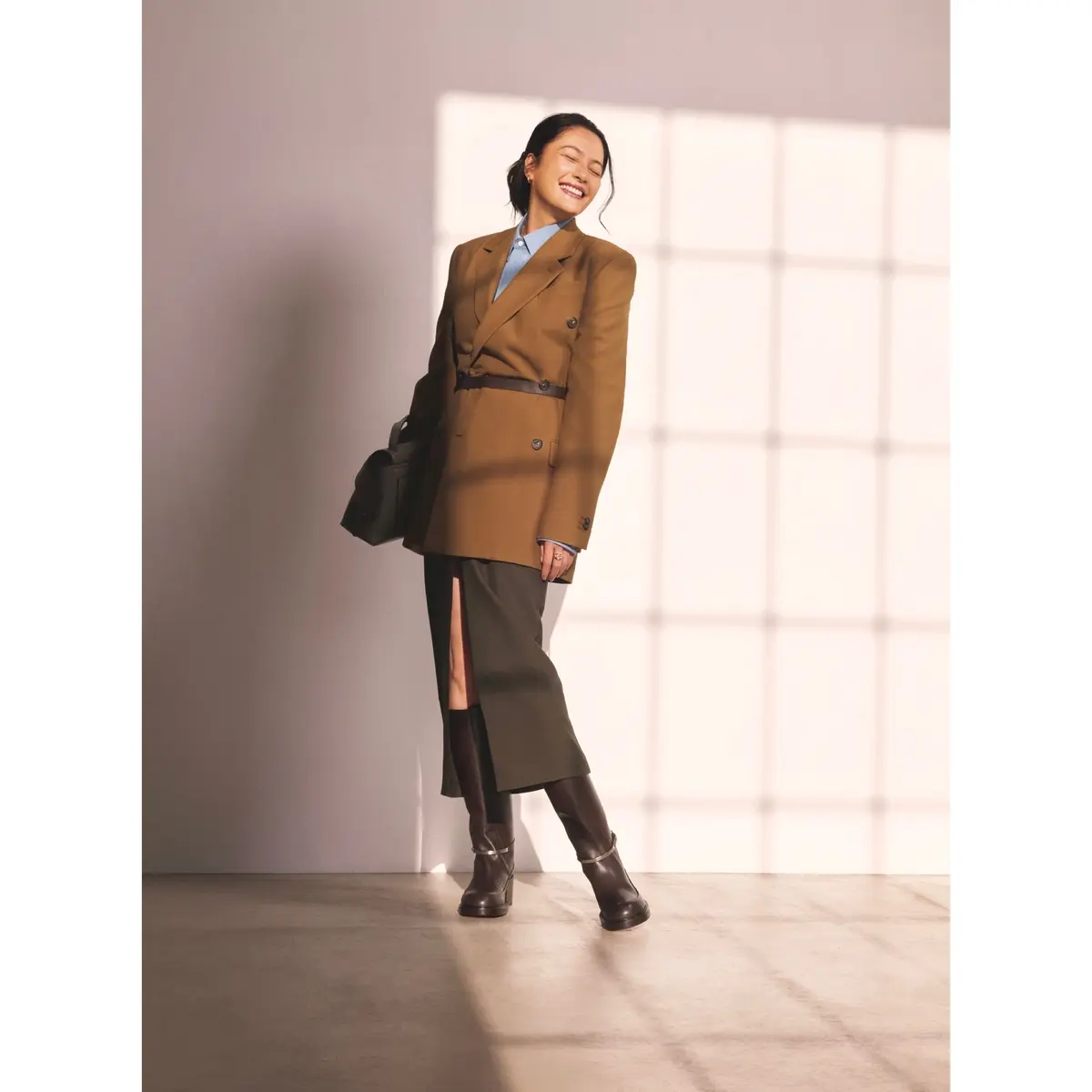 キャメルのダブルボタンジャケットにライトブルーシャツ、カーキのタイトスカート、ロングブーツを合わせたコーディネート　モデル・熊沢千絵
