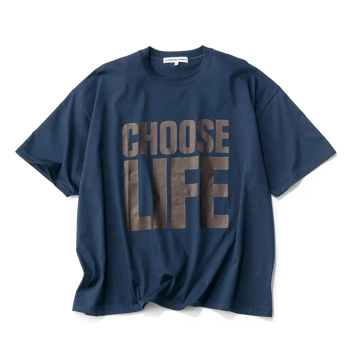 濃紺色のTシャツに、茶色の「CHOOSE LIFE」の文字がプリントされている。ゆったりとしたシルエットで、胸元中央に配置されている。背面上部には「katharinehamnett」のロゴが入っている。