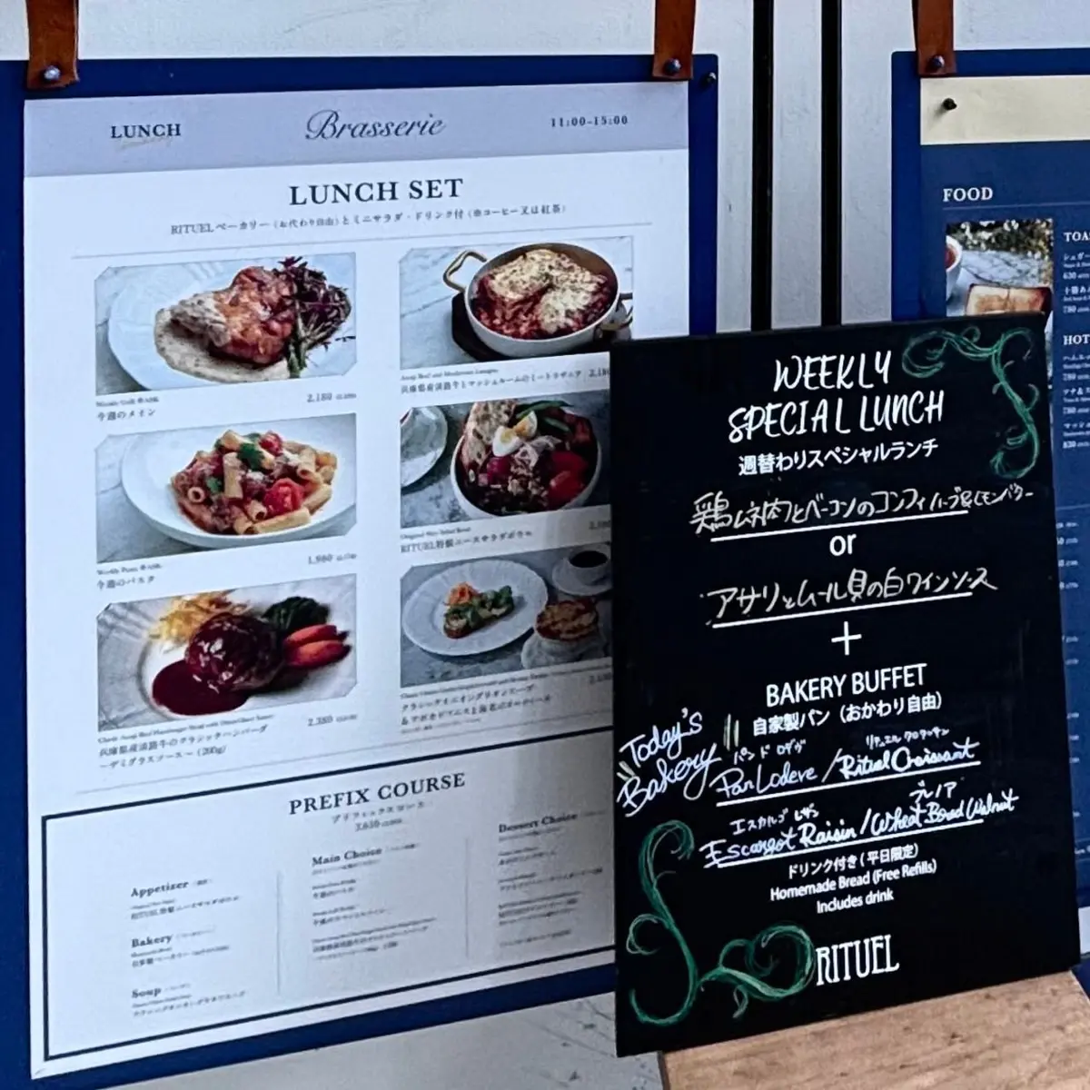 虎ノ門 RITUEL レストランのランチメニューと週替わりランチ特別メニューが並ぶ掲示板。