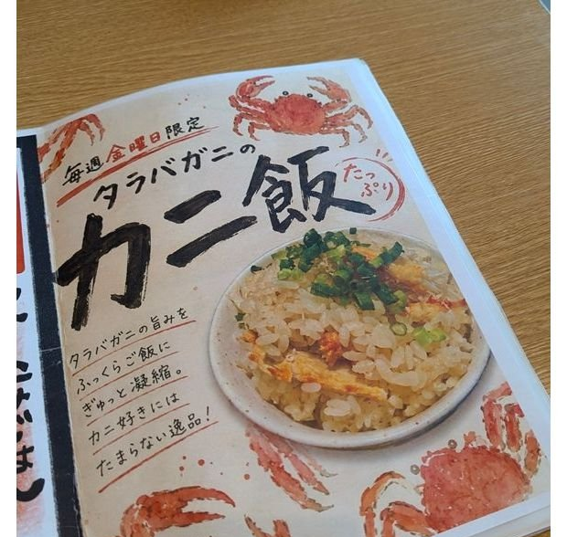 毎週金曜日限定の「タラバガニのカニ飯」メニューの告知。カニのイラストと湯気が立つカニ飯の写真が配置され、手書き風の文字で商品の説明が添えられている。