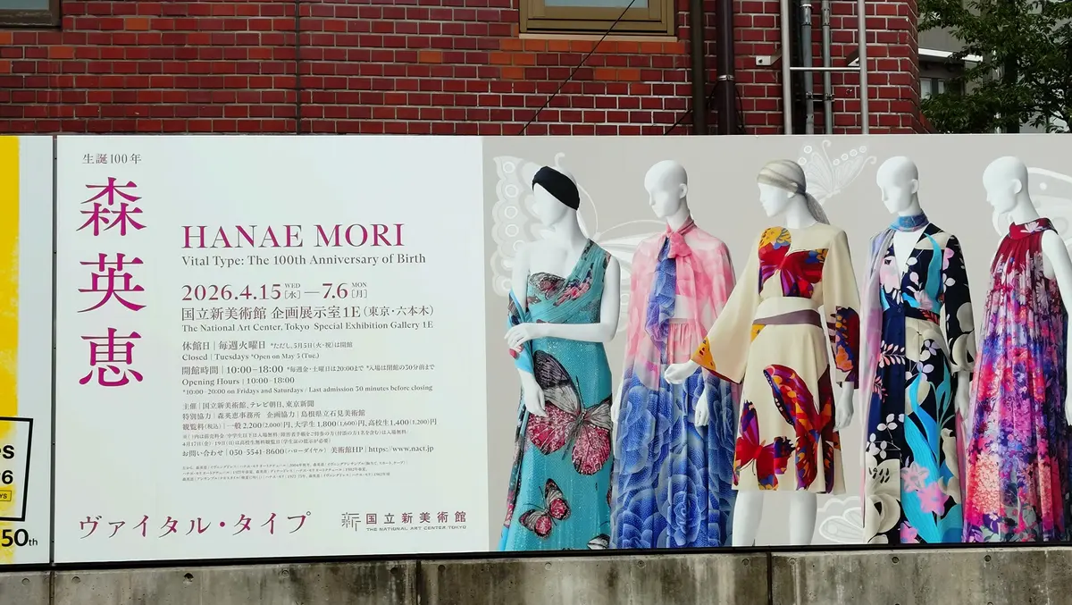 花江美枝生誕100周年記念展のポスターと、蝶の模様が施されたカラフルなドレスを着たマネキンの並び