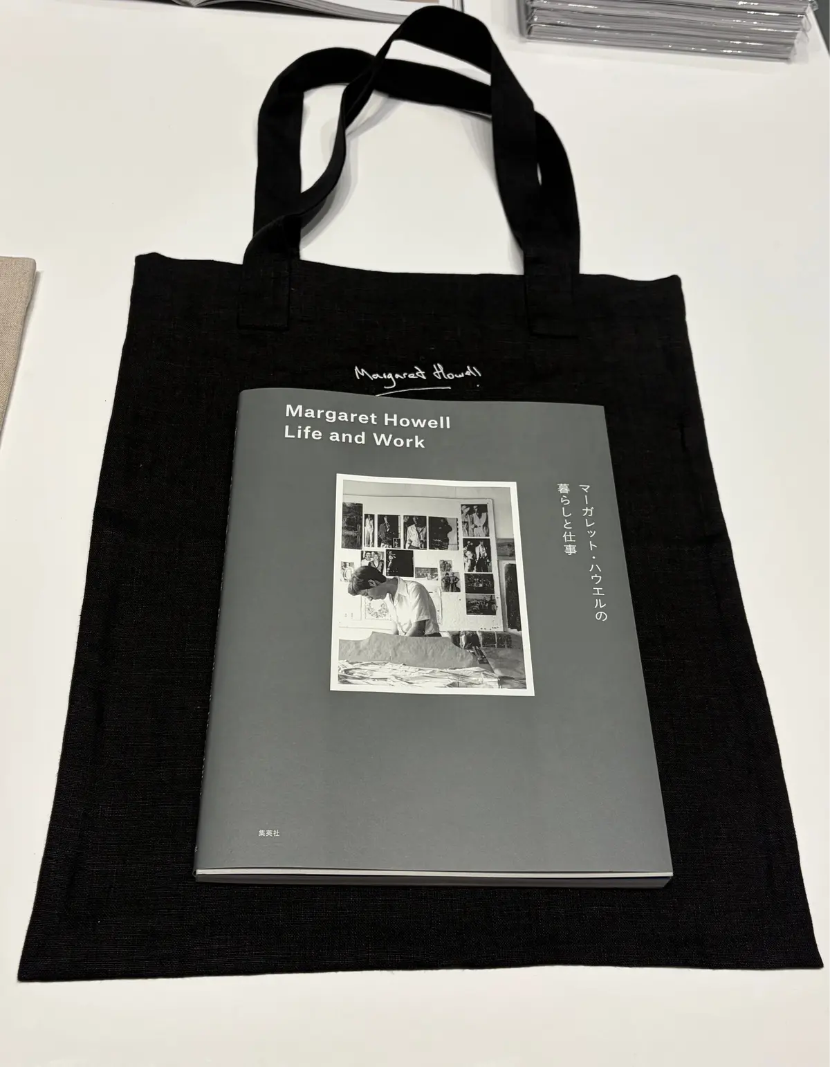 黒い布製のトートバッグと、「Margaret Howell Life and Work」新刊