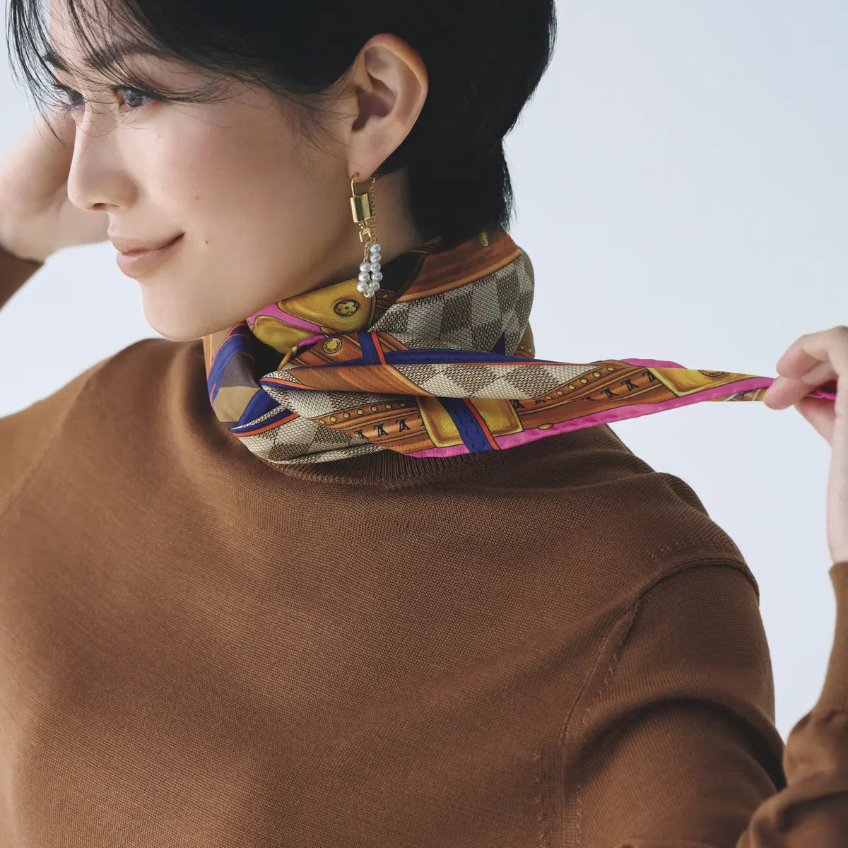 クロスした端を後ろ側に持っ ていき、2回結ぶ