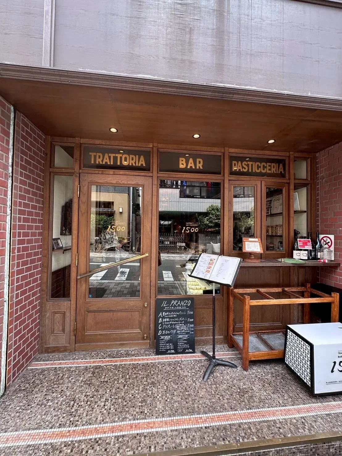 イタリア料理店「1500（ミレチンクエチェント）」の入り口。窓に「1500」の表示があり、黒板にランチメニューが書かれている。建物の壁はベージュと赤レンガ。