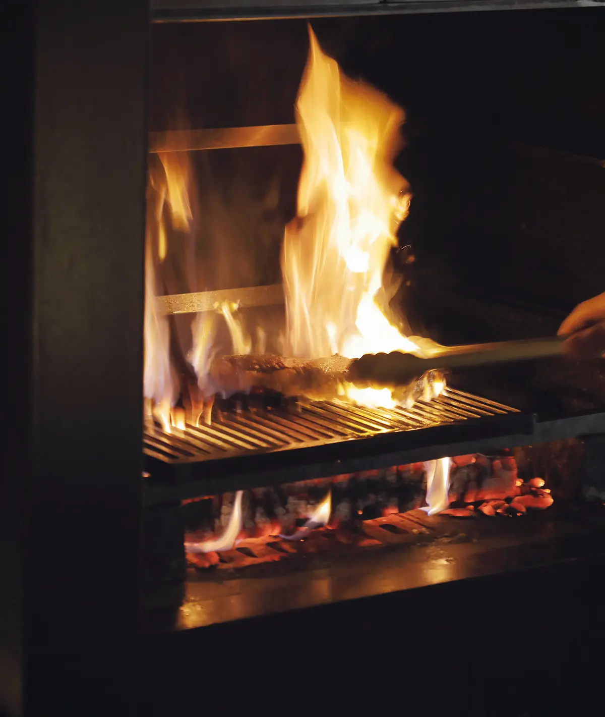 店内には薪窯を備えた作 業台が設けられ、照明を落 とした空間は舞台のように 目をひく