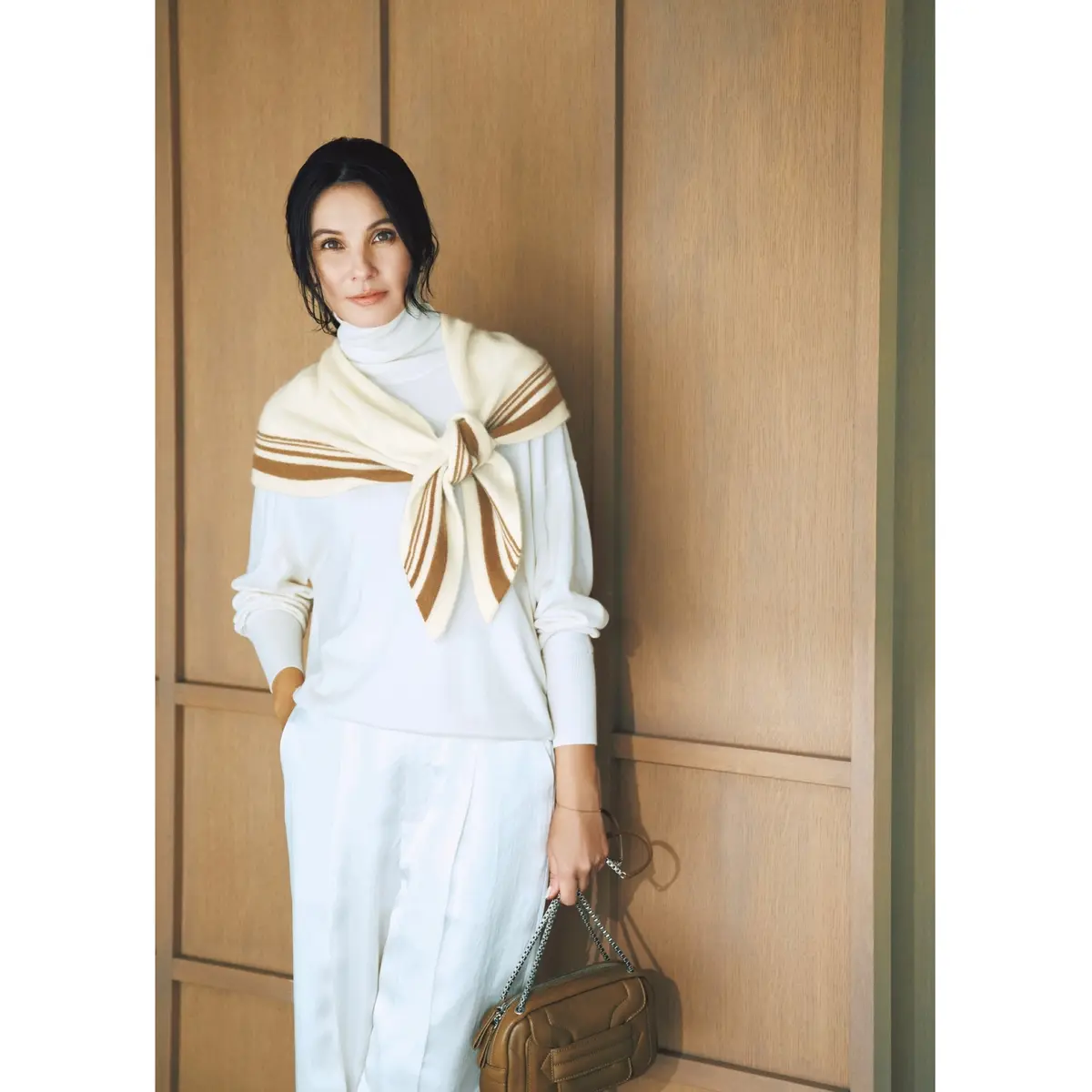 白のタートルネックニットに白パンツを合わせ、肩にクリーム色のニットストールを巻いたコーディネート　モデル・田沢美亜　